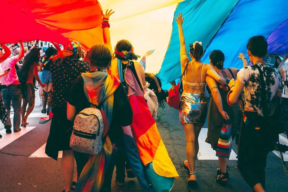 People marching under a rainbow flag