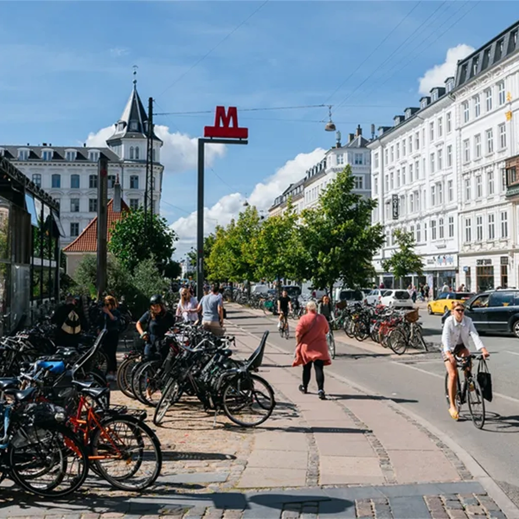 Cyclist riding along path and cars on street in Copenhagen