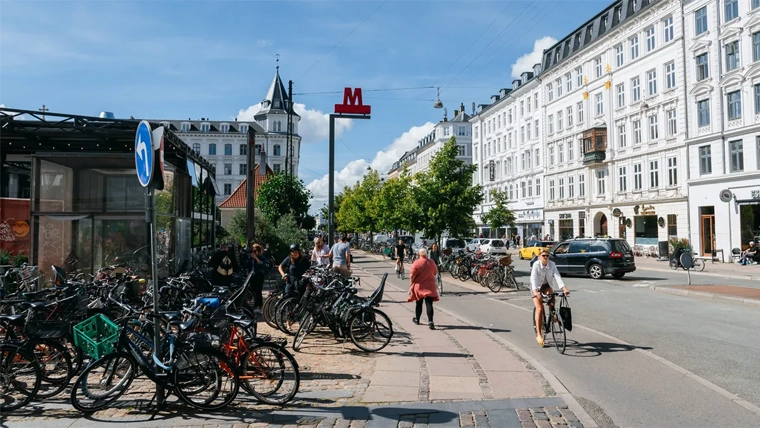 Cyclist riding along path and cars on street in Copenhagen