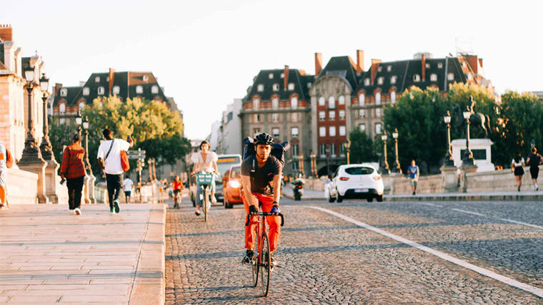 People walking and cycling over a bridge