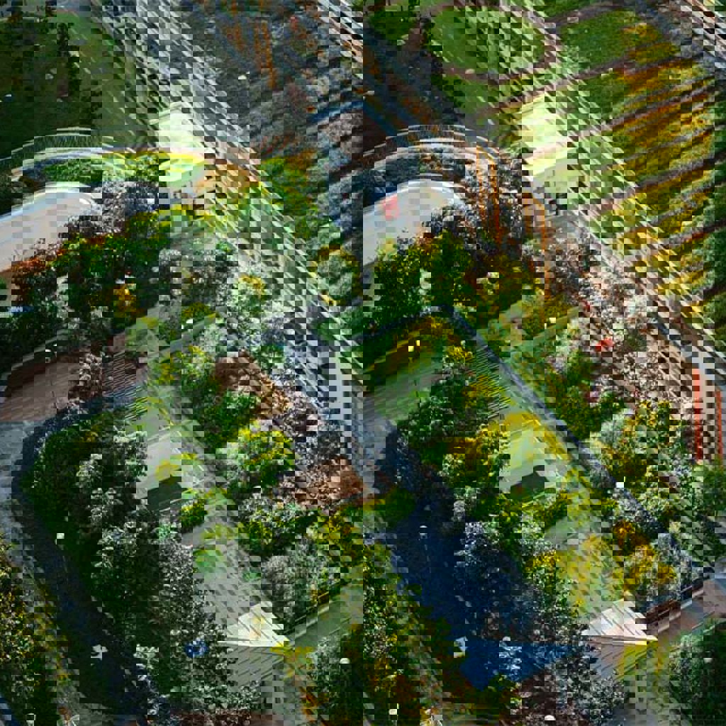 A building with a green lawn and trees in front of it.