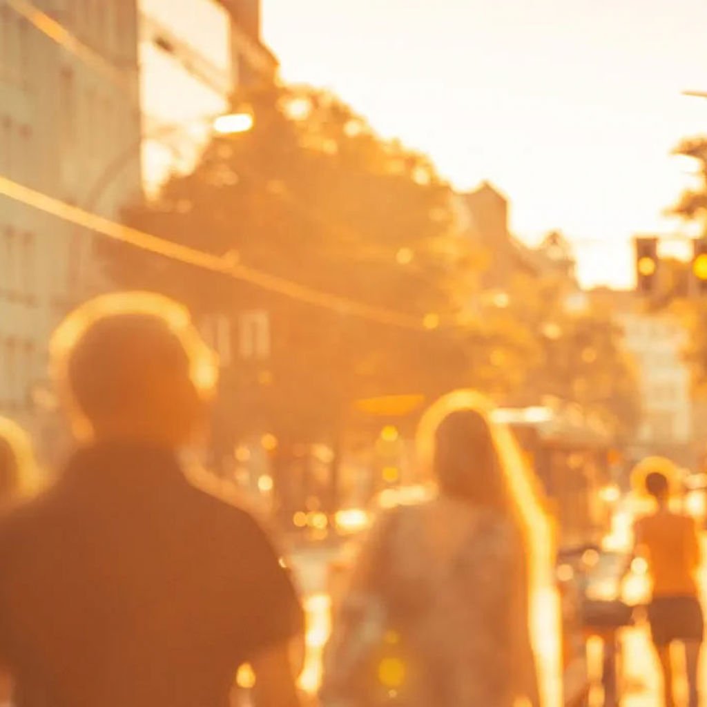 People walking down a city street in the sun