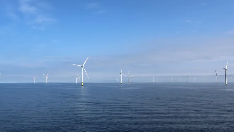 A group of wind turbines in the water.