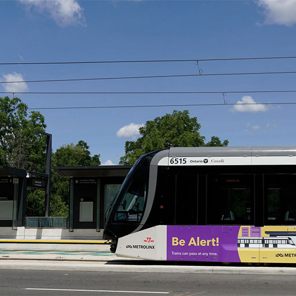 Side view of a light rail train traveling at grade
