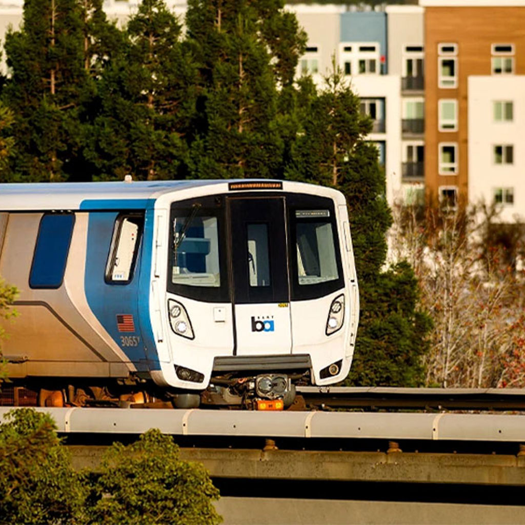 A train on the railway tracks with buildings and trees in background