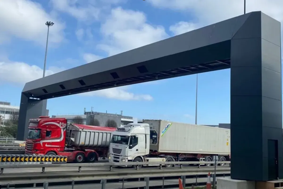 Trucks passing under toll barrier.
