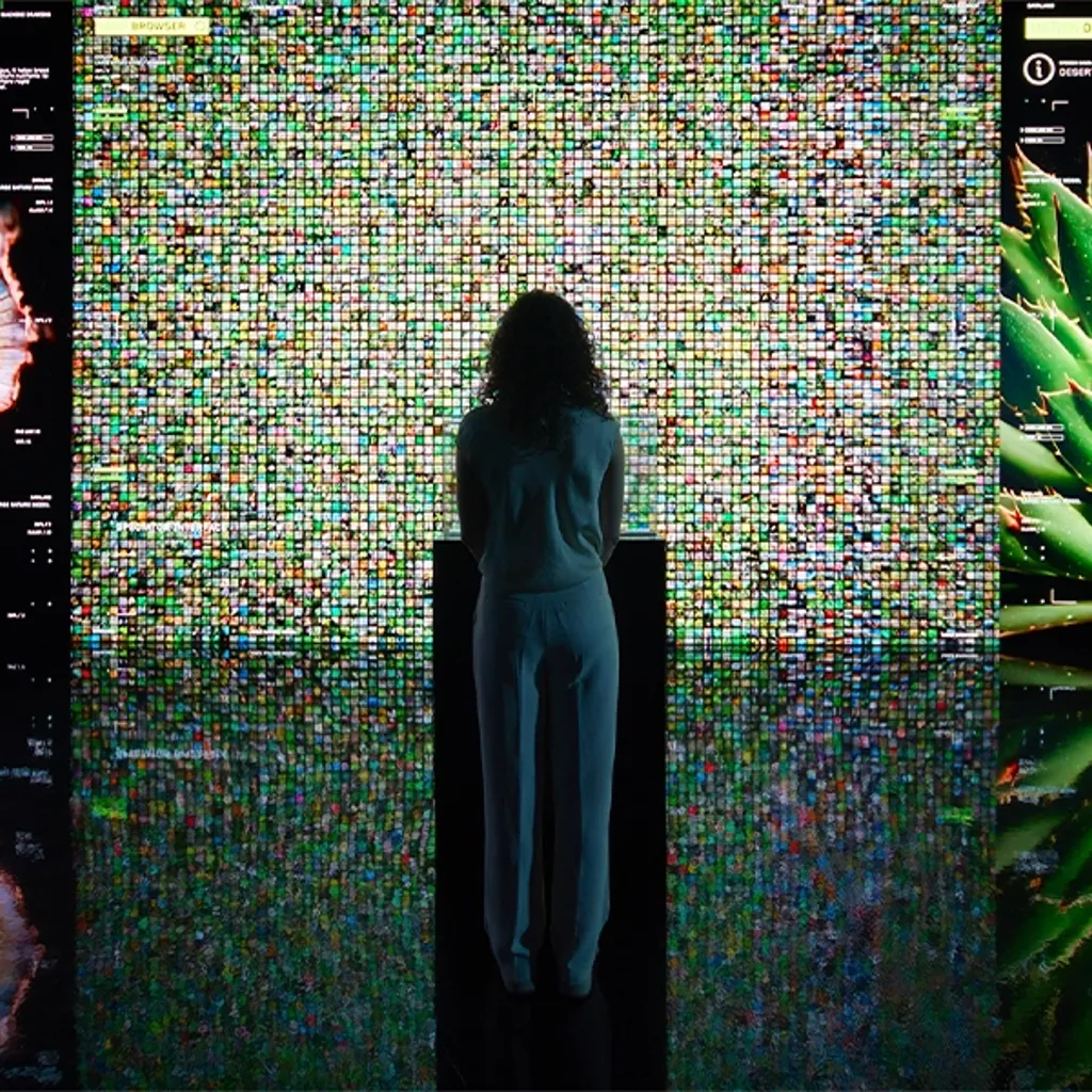 A person standing in front of a wall of colorful lights.