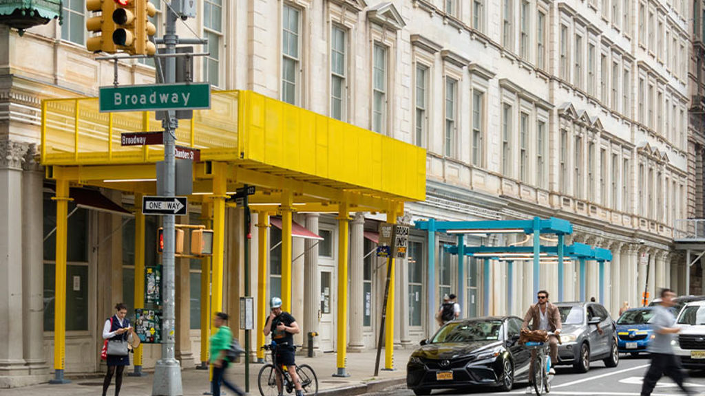 A street corner and building with colorful scaffolding sheds