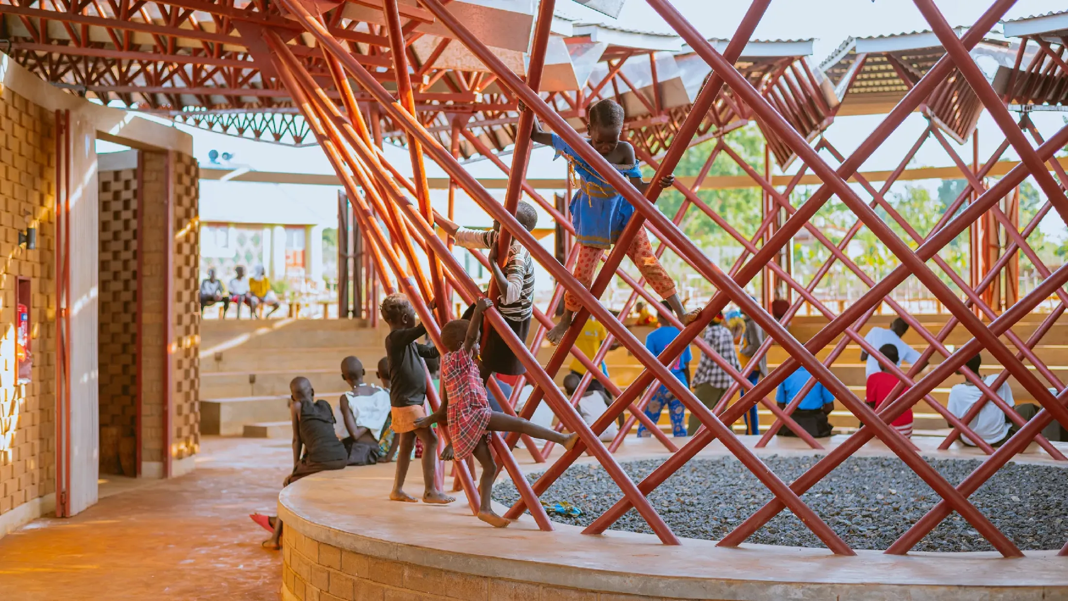 Children sat around and climbing on frame of Bidi Bidi's new fresh water facility