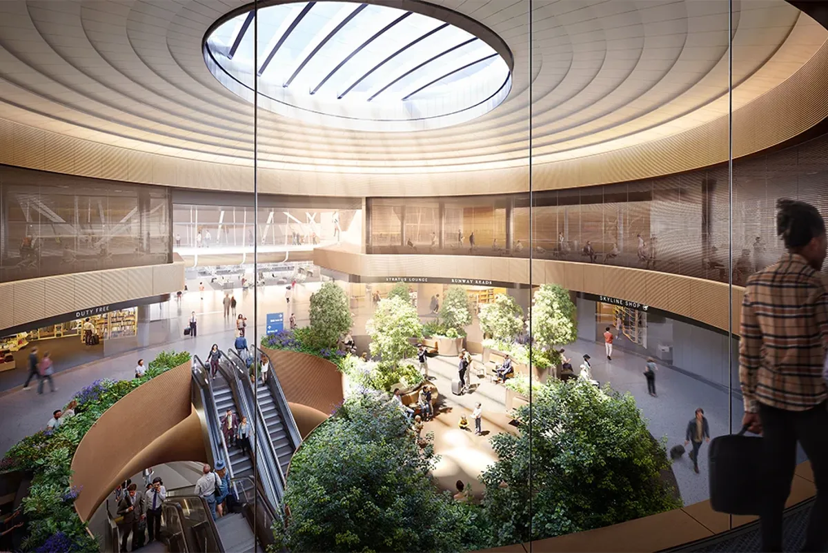 A large indoor terminal seen from above with escalators and travelers moving around