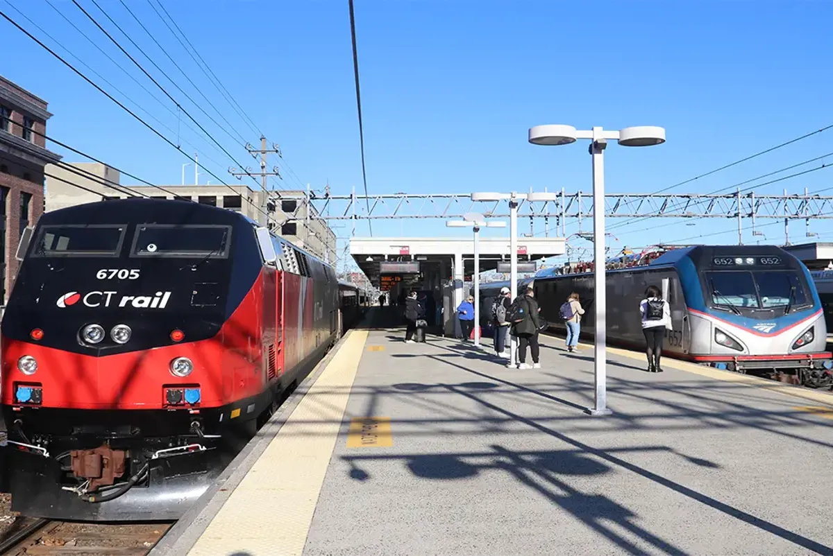 A group of people waiting for a train on a platform