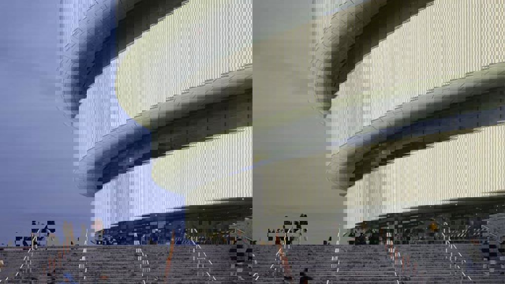 People walking up stairs to a building.