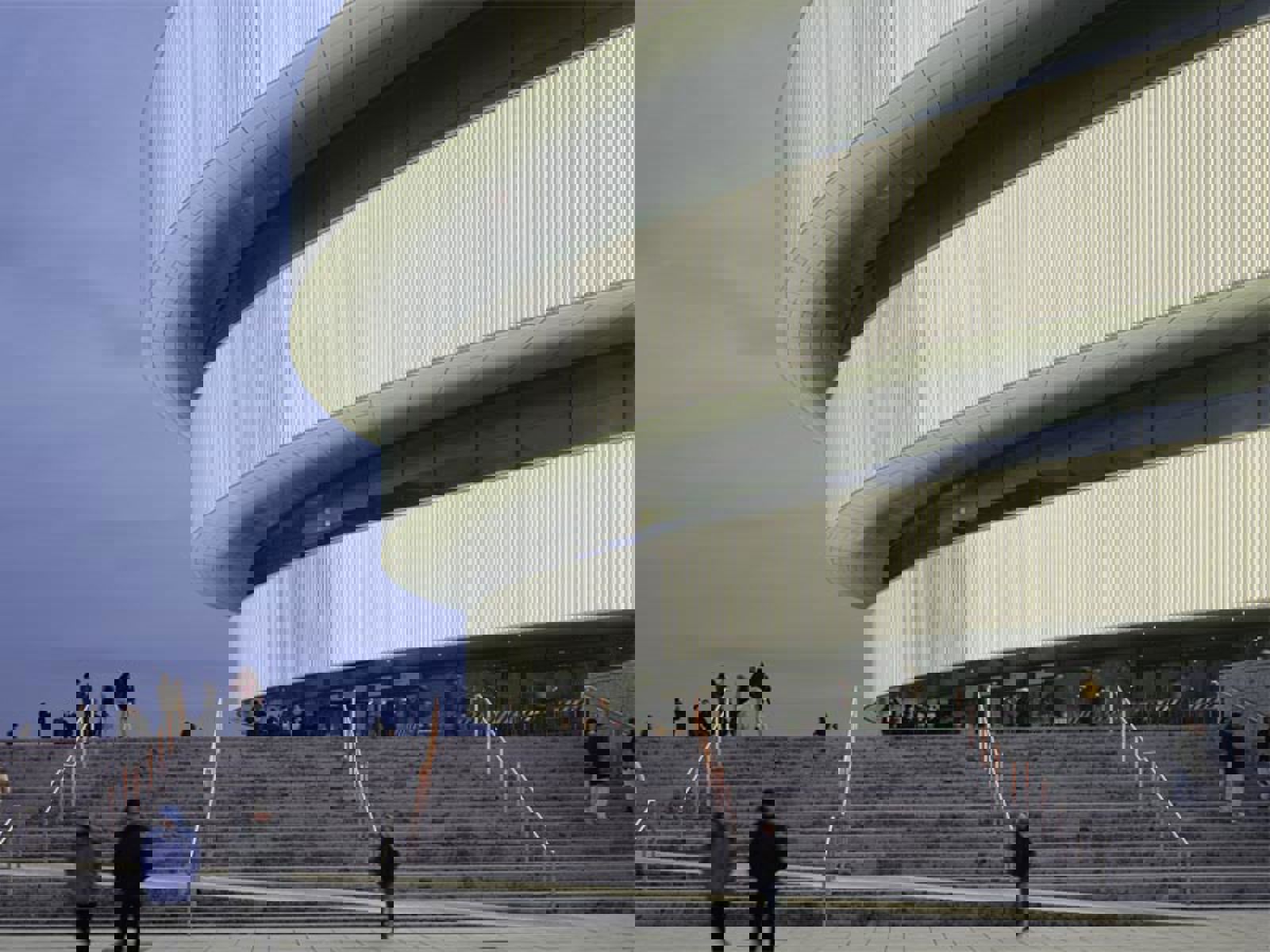 People walking up stairs to a building.