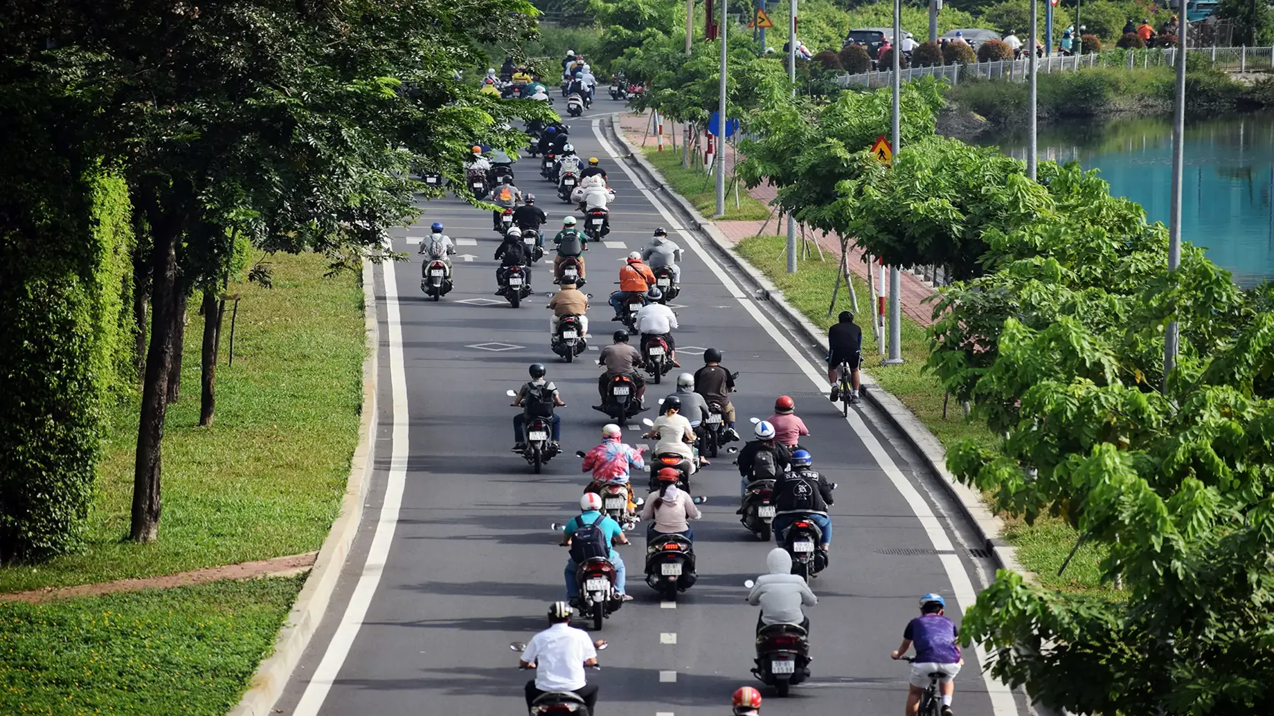 A group of people riding motorcycles down a road.