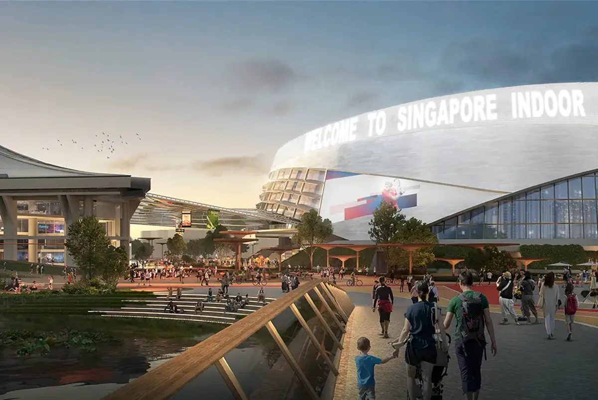 People walking along the waterfront near a sports stadium
