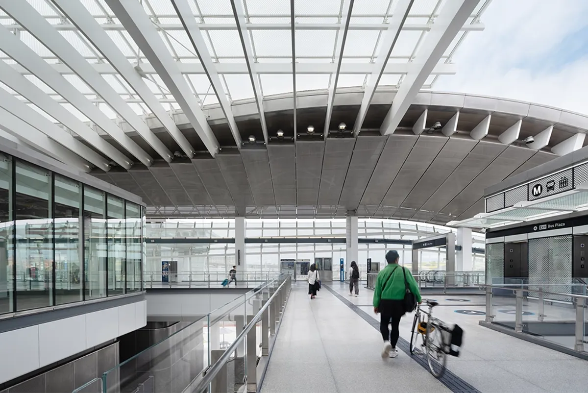 A person walking across a large open air transit center