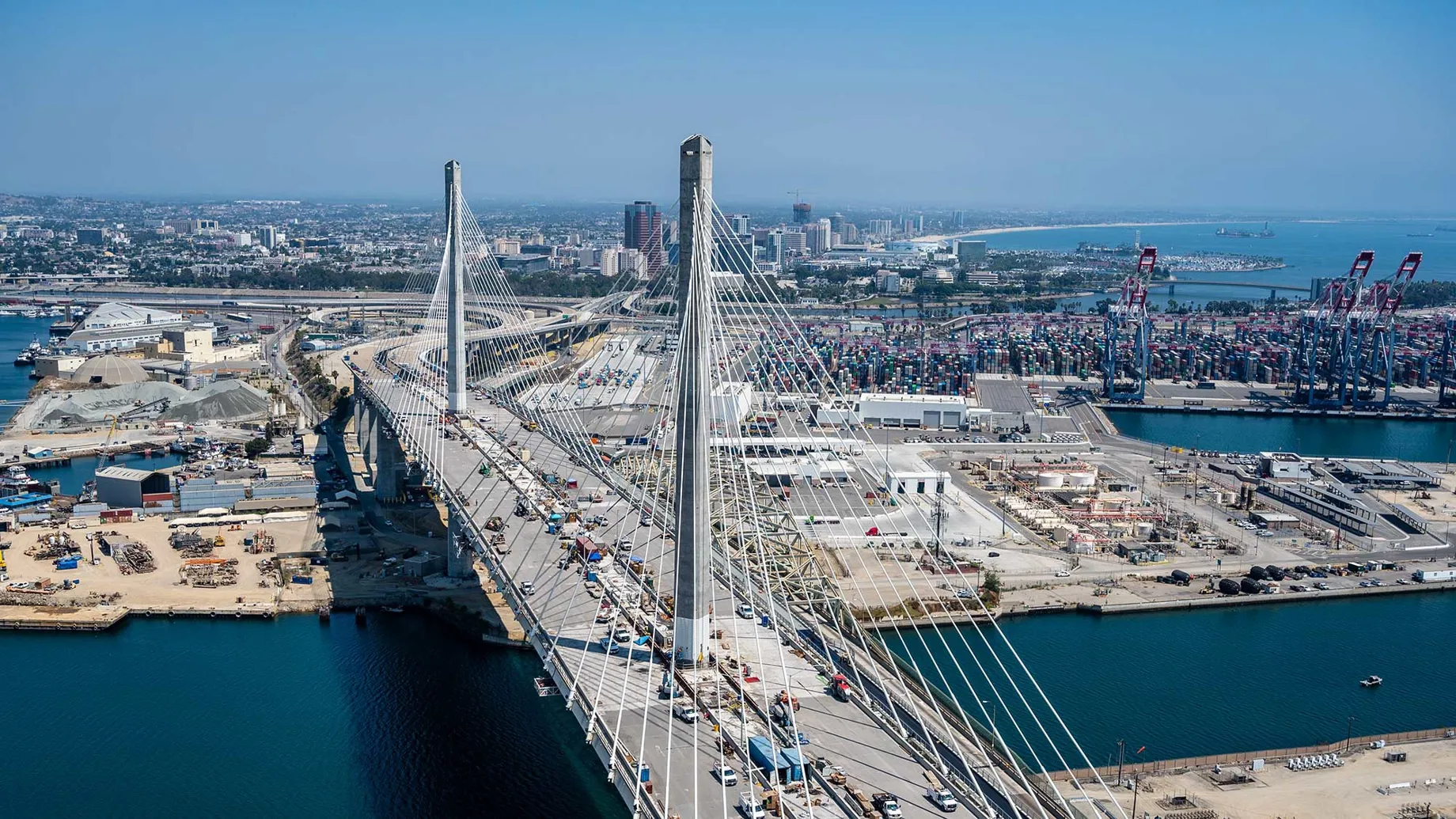 Front view of a cable-stayed bridge with the city of Long Beach in the background