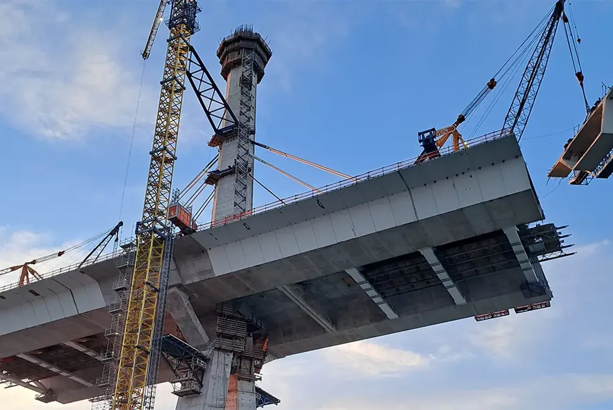 A large white building with cranes.