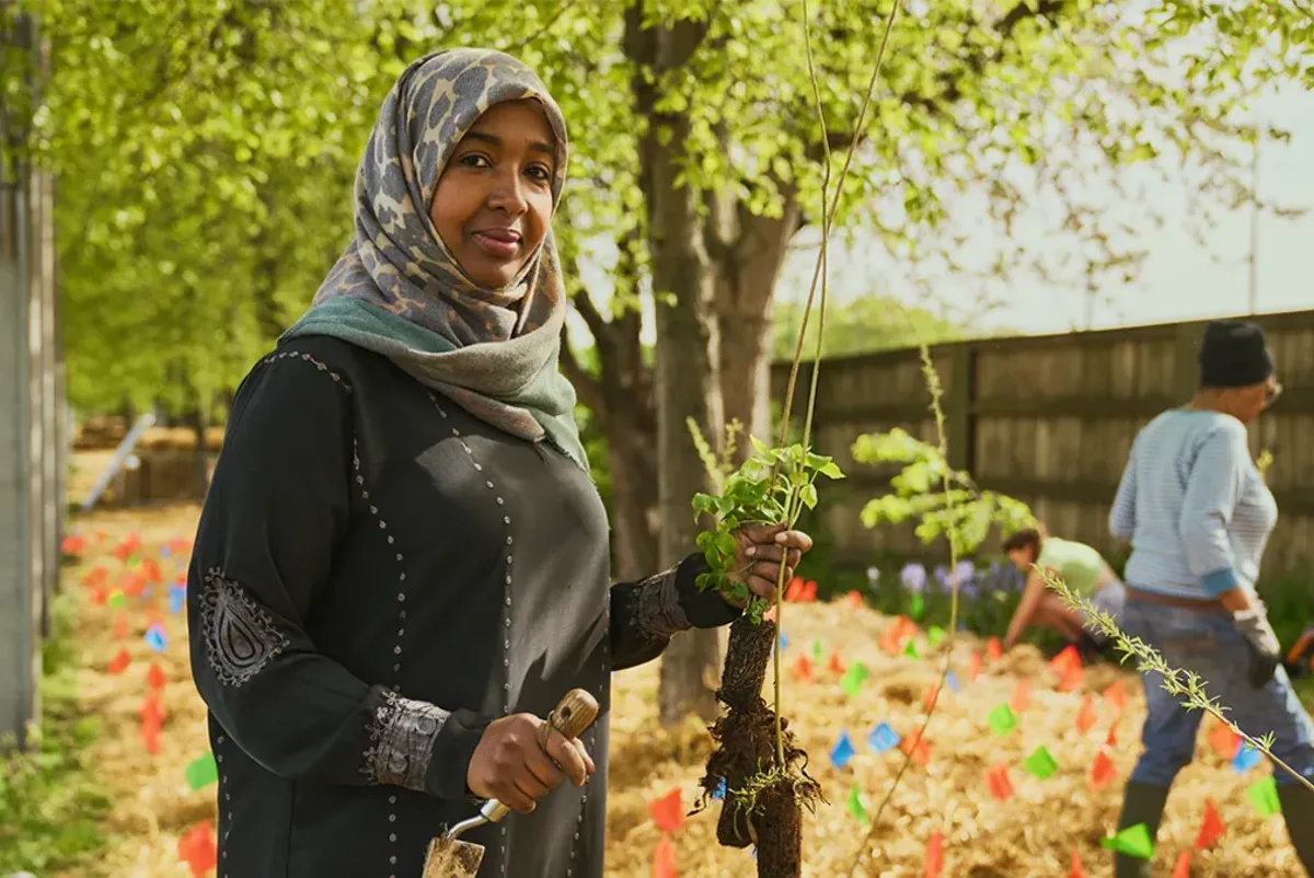 A person holding a tree branch.