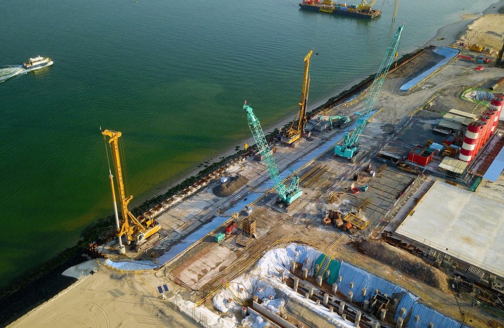 View over a construction site for an offshore marine centre in Singapore with cranes and machinery