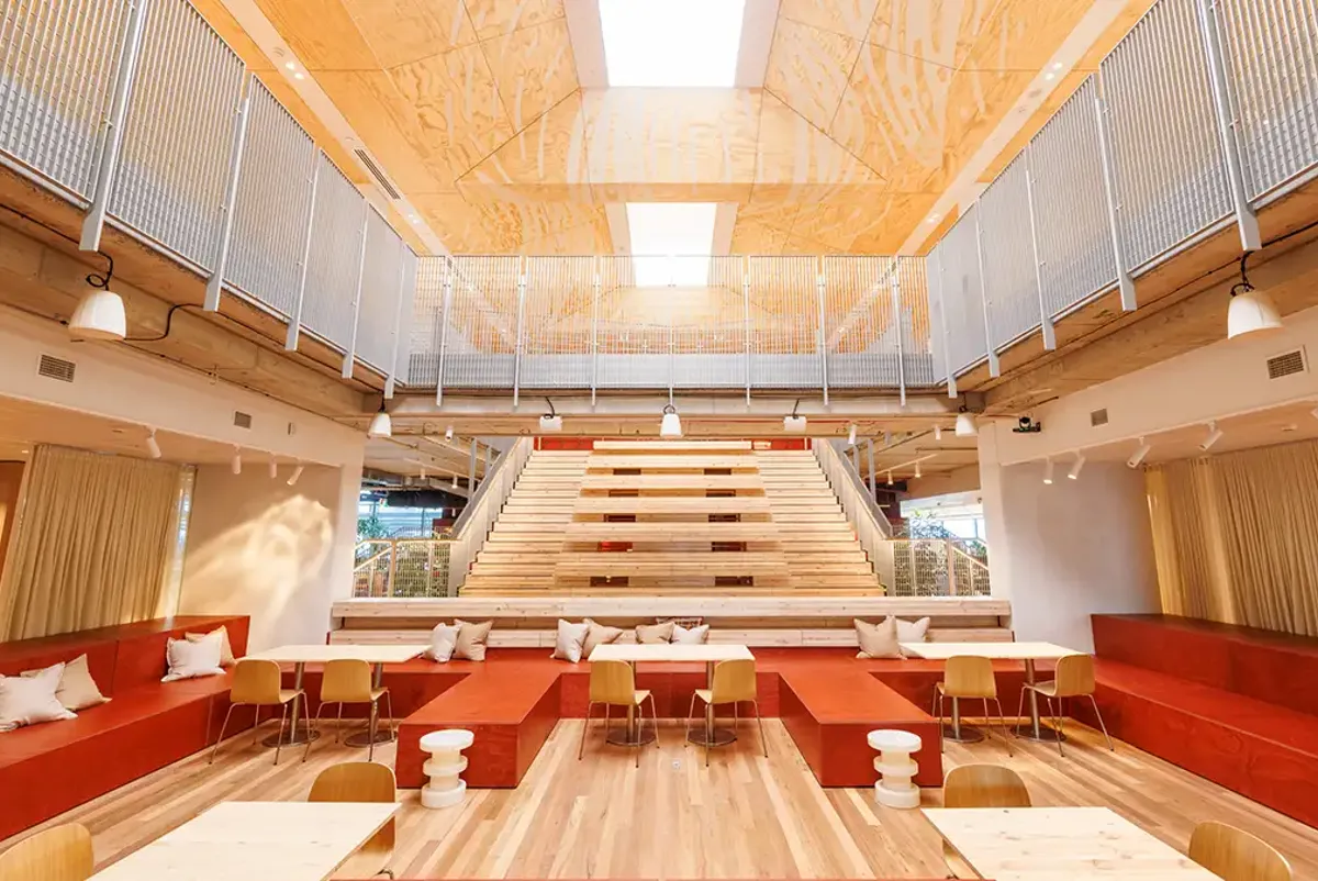 Large open space, high atrium, with rows of seats and tables for events and gatherings.