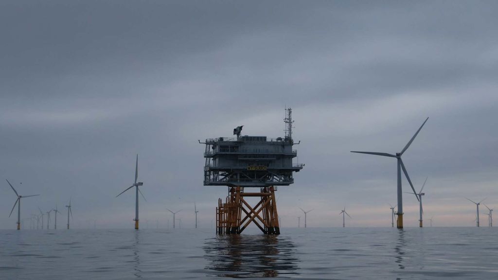 A group of windmills in a body of water.
