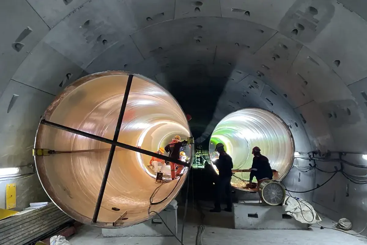Installation of pipes inside bored tunnel lining