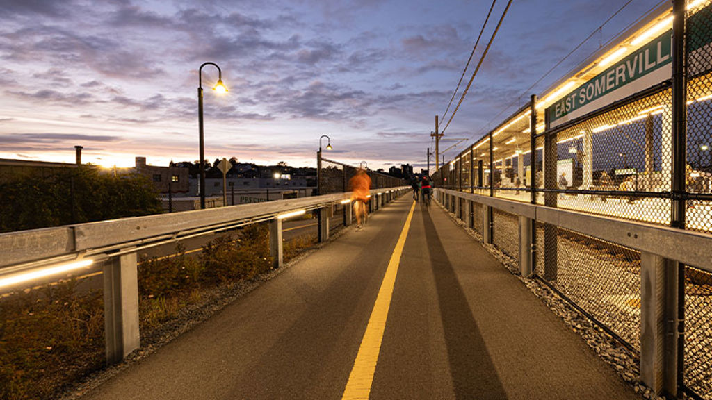 A community path next to a train station at dusk