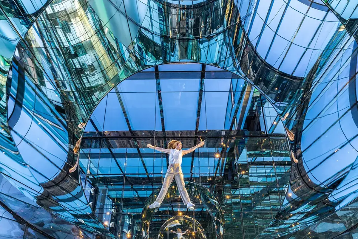 A person climbing a glass structure.