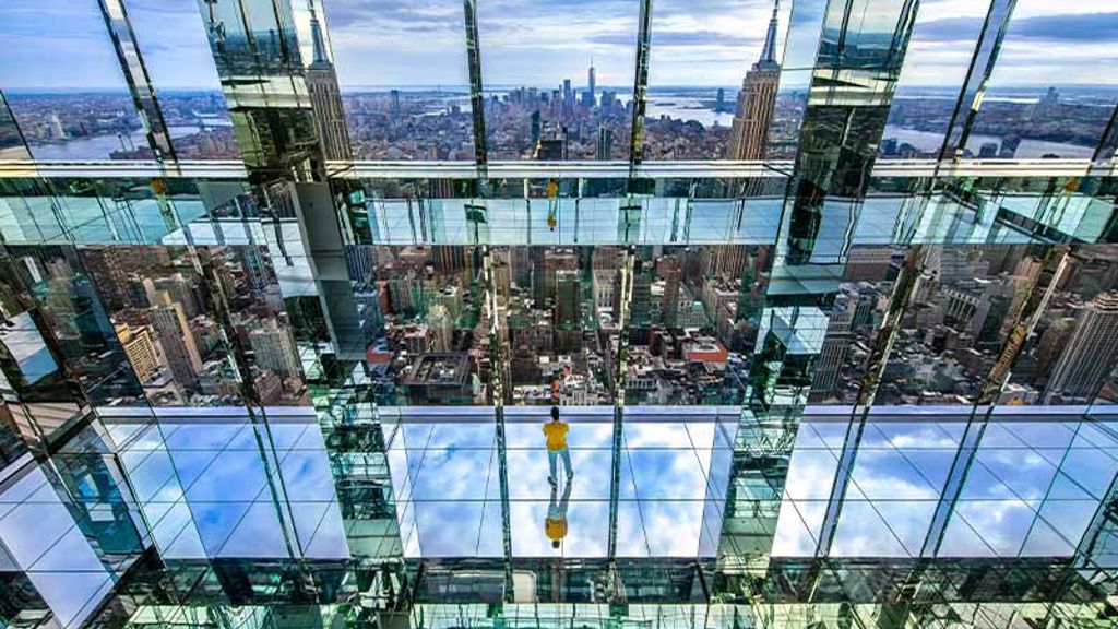 A group of people standing in a glass building.