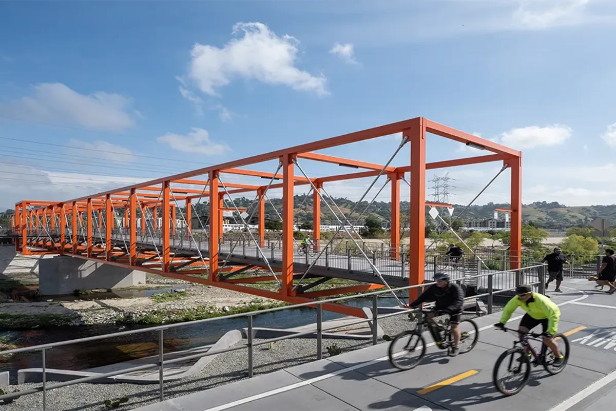 A group of people riding bikes on a bridge.