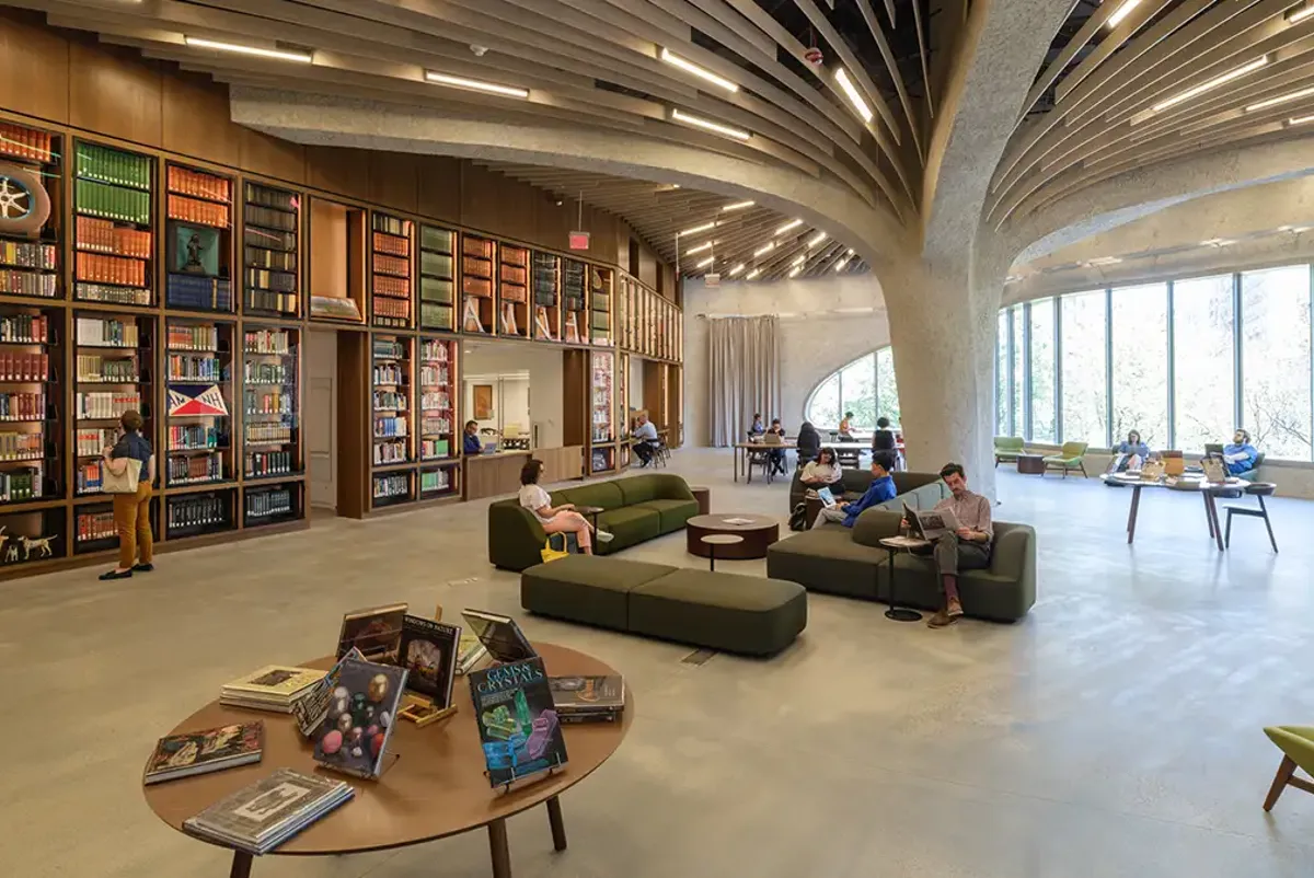 A library with people sitting on couches and books.
