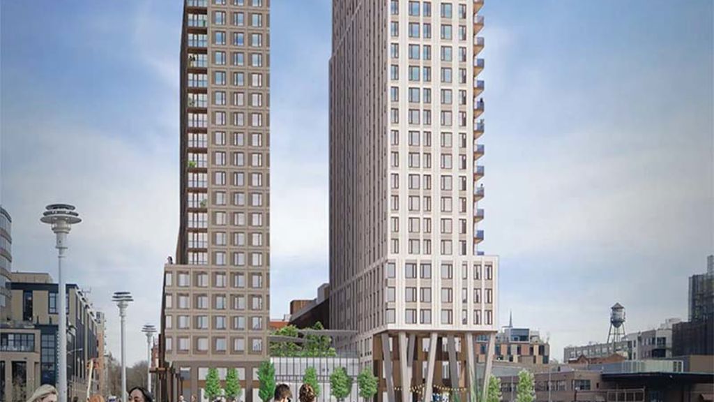 A group of people walking on a path between two tall buildings.