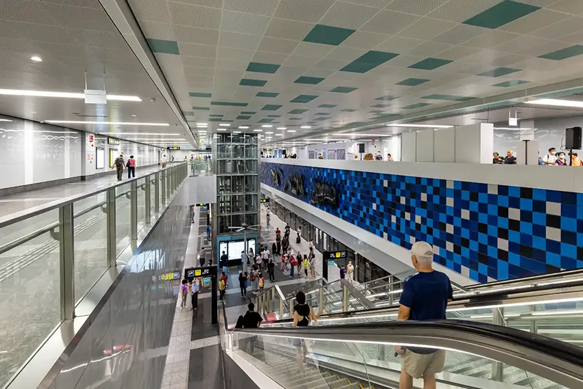 Passengers descending escalators in an underground rail station