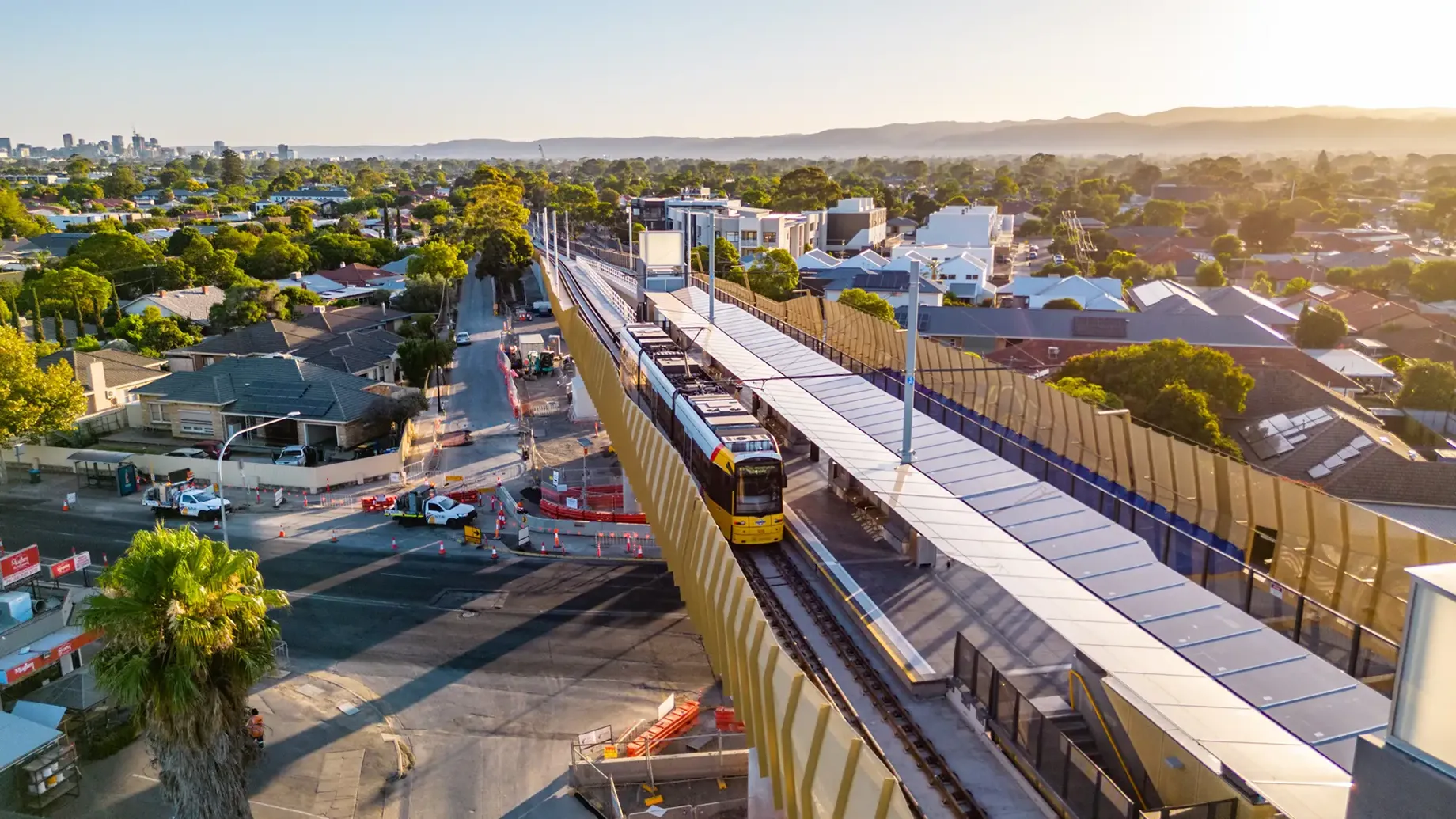 Elevated tram line crossing over a road with vehicles passing underneath