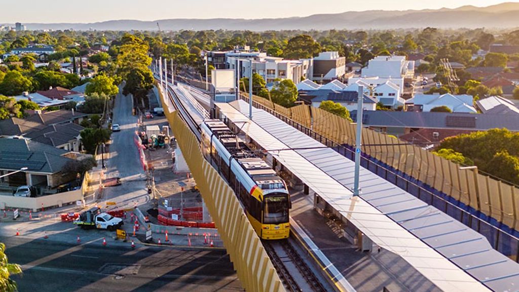 Elevated tram line crossing over a road with vehicles passing underneath